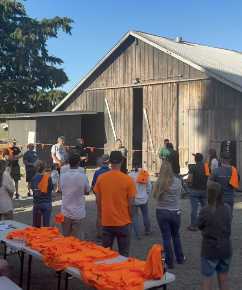 Volunteers gathered outside the barn in orange shirts before serving