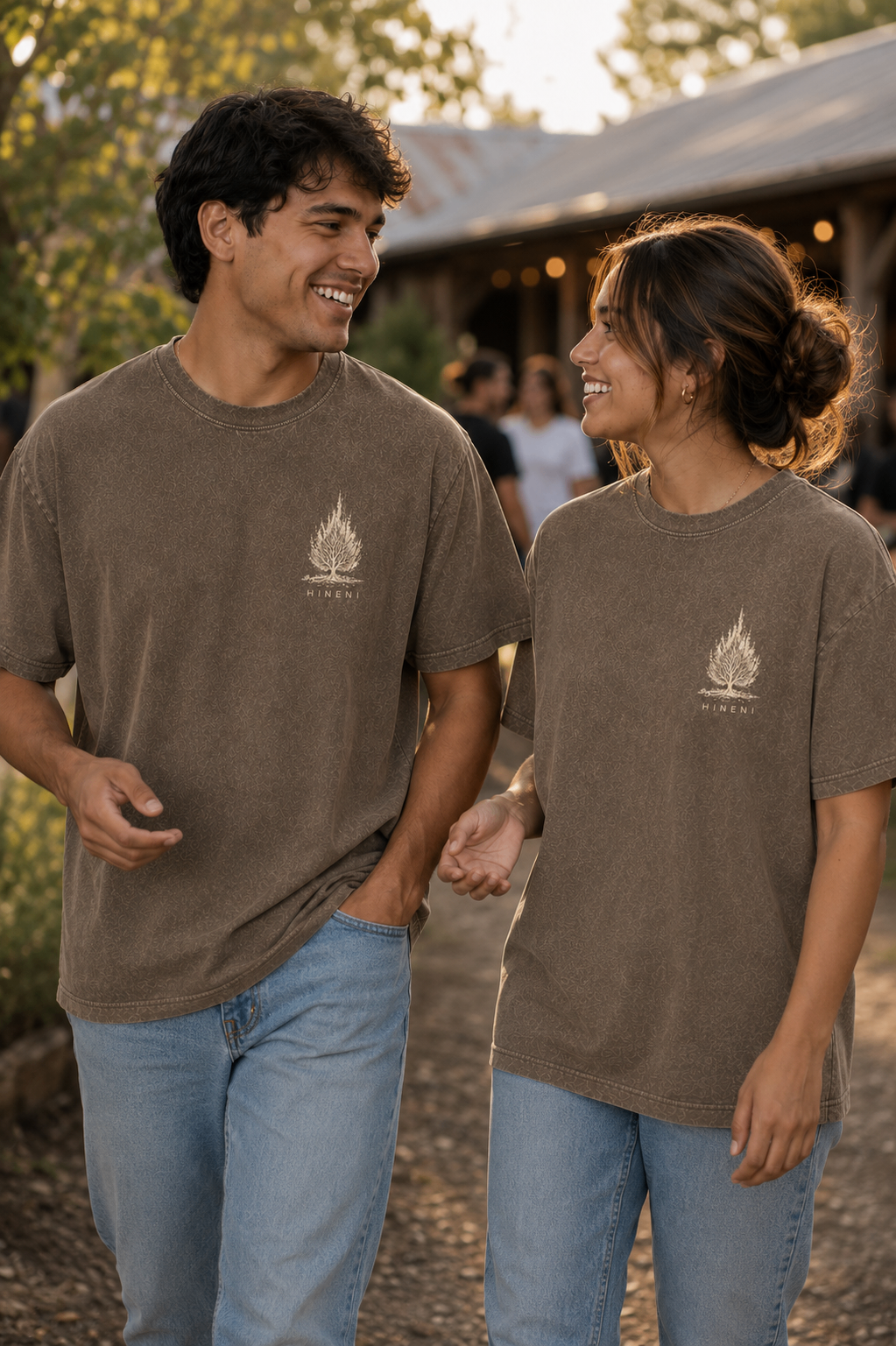 Couple wearing the HINENI shirt, front view with the tree logo